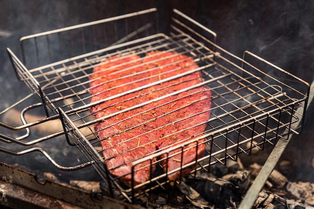 Koken buiten een gekruid denver steak vlees op de grill barbecue