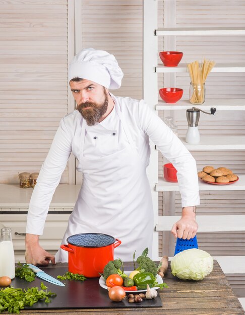 Koken chef-kok op keuken knappe bebaarde chef-kok in uniforme ingrediënten professionele keuken gezond