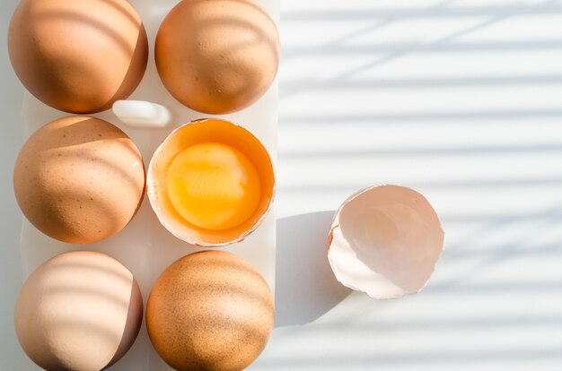 Koken eieren van kippeneieren vroeg in de ochtend in de keuken. Schaduwen van de luiken op de vensterbank.