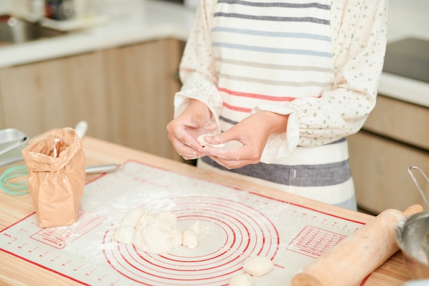 Koken en thuisconcept - close-up van vrouwelijke handen die deeg thuis kneden