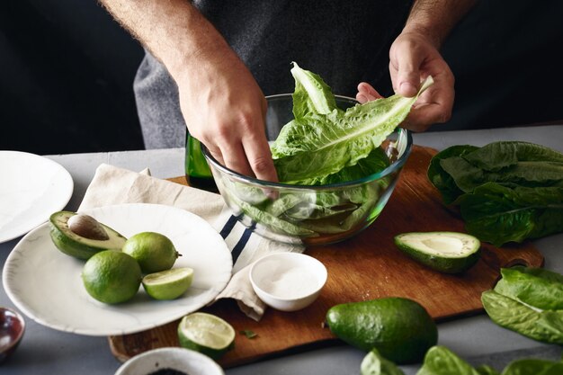 Koken gezond dieet voedsel concept. mens die een salade van groene groenten kookt