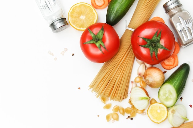 Koken, groenten en pasta liggen op een lichte achtergrond.