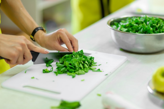 Koken in de keuken snijdt greens