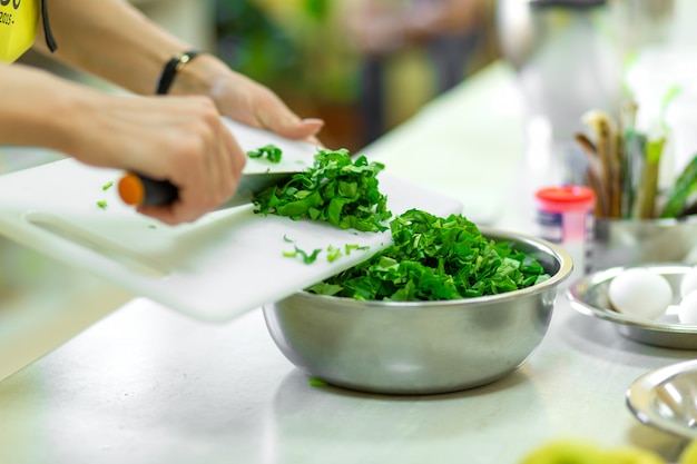 Koken in de keuken snijdt greens