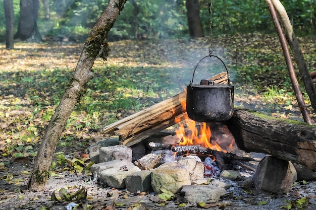 Koken in de natuur. Ketel in brand in bos