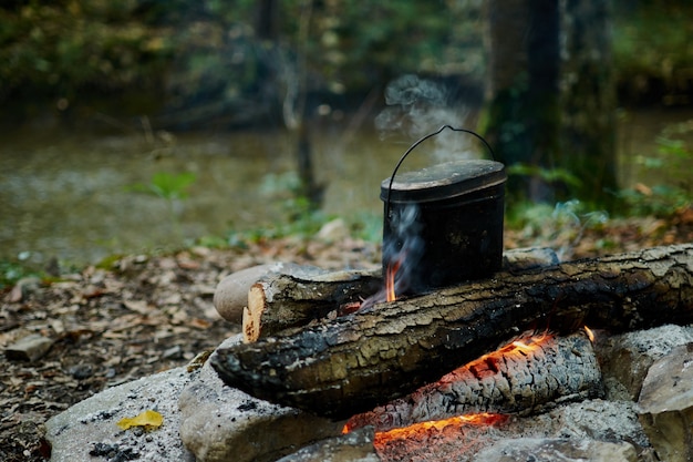 Foto koken in een pan boven het kampvuur