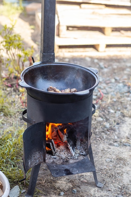 Foto koken in ketel op open vuur in de natuur