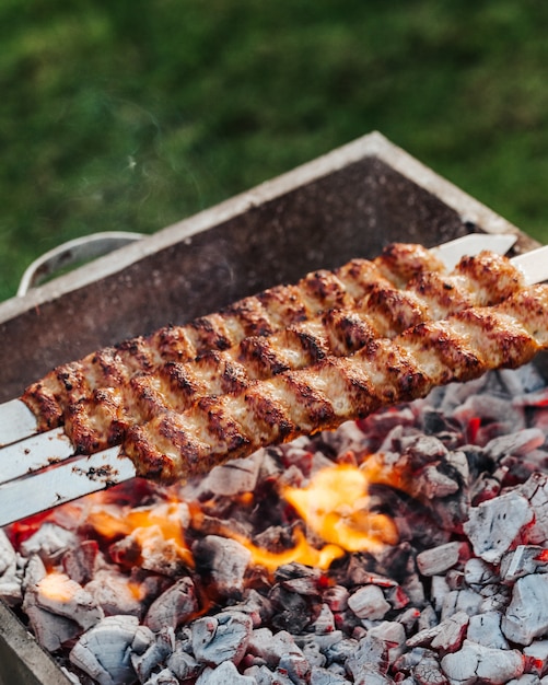 Koken kebab vlees met spiesjes op de grill.
