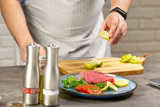 Koken met notebook tonijnsteak in huis keuken online koken recept concept vis koken thuis