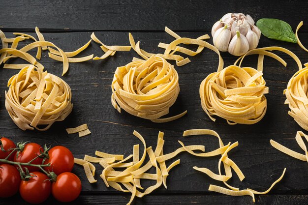 Koken tagliatelle pasta en ingrediënten set, op zwarte houten tafel