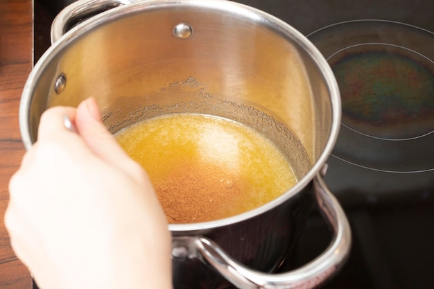 Kokend deeg voor peperkoek een pot honing op het fornuis in de keuken