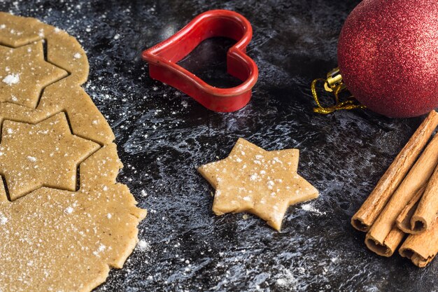 Kokende de peperkoekkoekjes van Kerstmis met ingrediënten en decor op dark