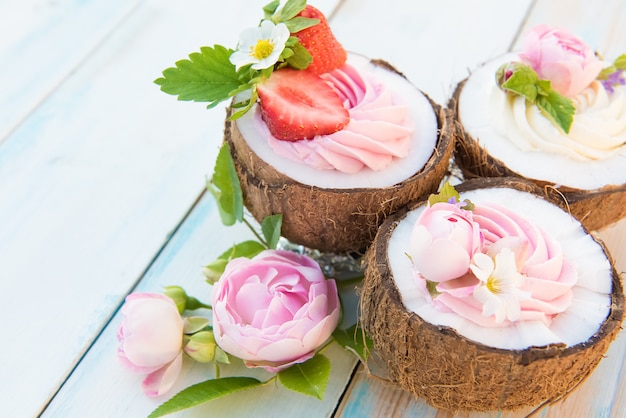 Kokos cupcakes met bloemen, aardbeien en kaasroom