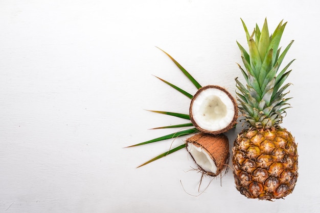 Kokos en ananas op een houten ondergrond Tropisch fruit en noten Bovenaanzicht Vrije ruimte voor tekst