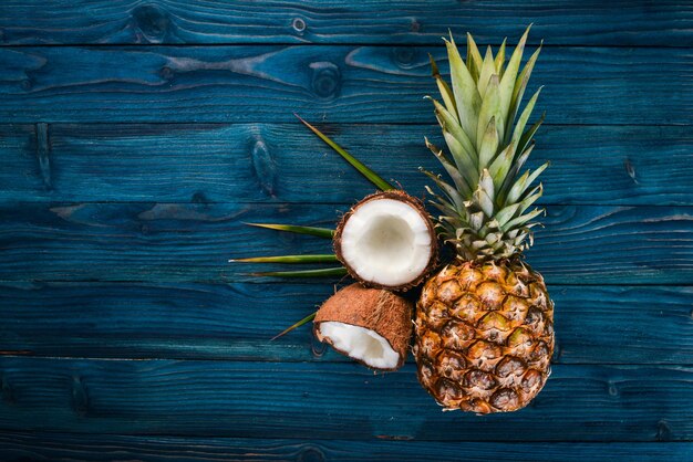 Kokos en ananas op een houten ondergrond Tropisch fruit en noten Bovenaanzicht Vrije ruimte voor tekst