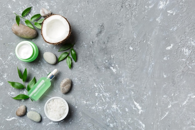 Kokosnoot met potten kokosolie en cosmetische crème op gekleurde achtergrond Bovenaanzicht Vrije ruimte voor uw tekst Natural spa kokoscosmetica en biologisch behandelingsconcept Coconut Spa samenstelling