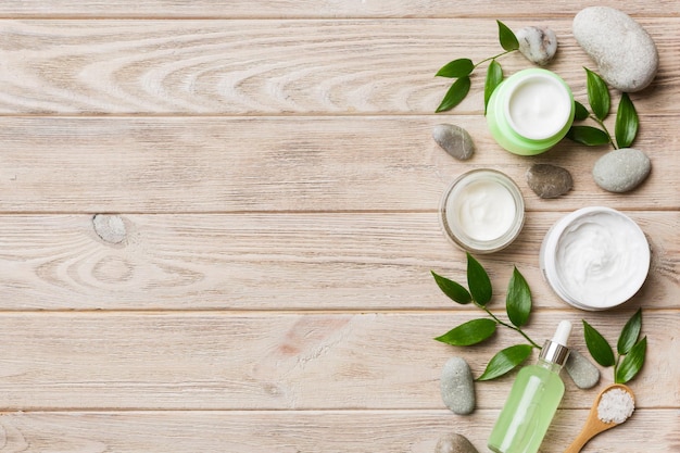 Kokosnoot met potten kokosolie en cosmetische crème op gekleurde achtergrond Bovenaanzicht Vrije ruimte voor uw tekst Natural spa kokoscosmetica en biologisch behandelingsconcept Coconut Spa samenstelling