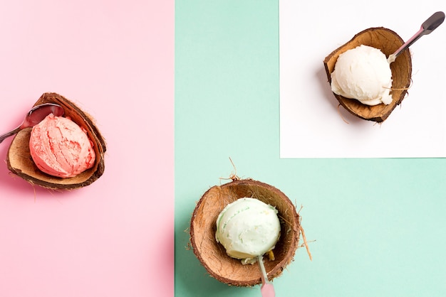 Kokosnoot schelpen met verse natuurlijke kleurrijke ijs op een duotoon met vel papier