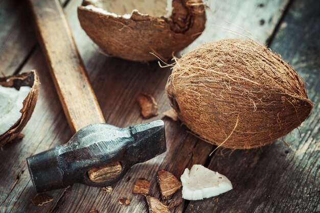 Kokosnoten en hamer op oude houten tafel