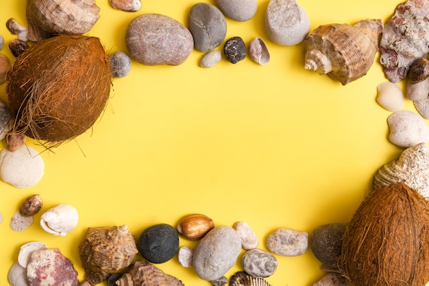 Kokosnoten, rotsen en schelpen op een gele achtergrond .Marine thema