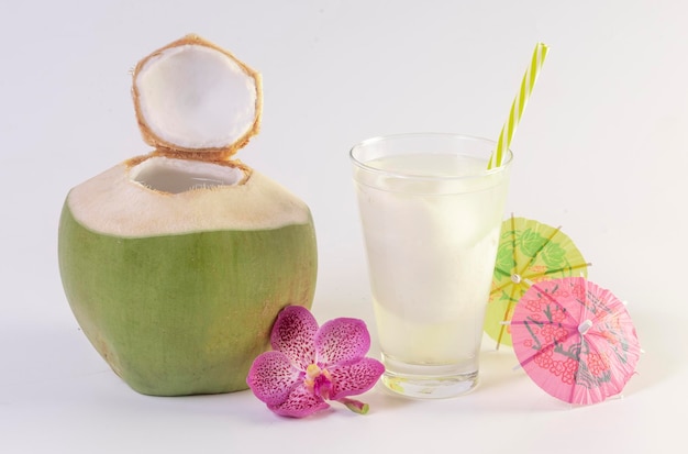 Kokossap met vers jong kokosfruit dat op witte achtergrond wordt geïsoleerd