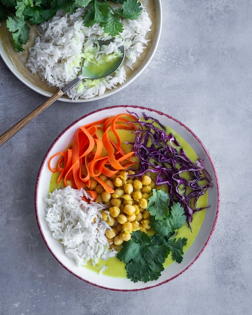 Kokossoep en groene curry met kikkererwten, basmatirijst en groenten. Zelfgemaakt eten.