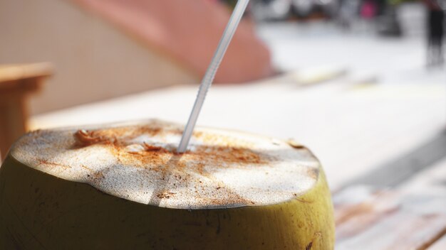 Kokoswater drinken op tafel met onscherpe achtergrond. strandcafé, reizen en ontspannen