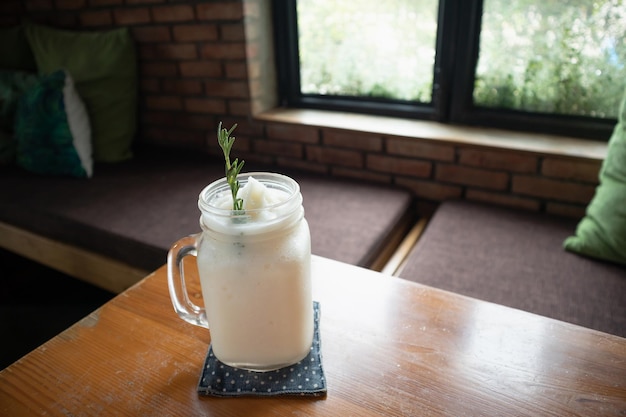 Kokoswater frappe met rozemarijnblad op restauranttafel