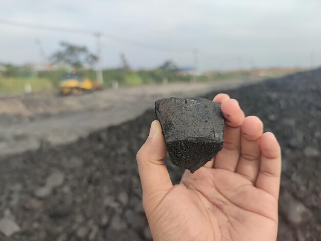 Kolenmijnbouw - mijnwerker in de mensenhanden van steenkoolachtergrond