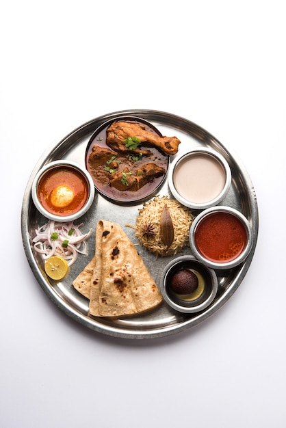 Kolhapuri chicken Thali is a popular Indian, asian food platter consists of poultry meat, egg curry with chapati ,rice, salad and sweet Gulab Jamun