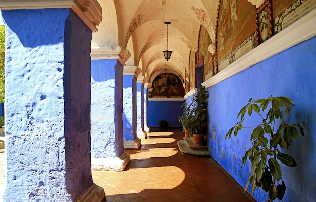 Kolommen van de blauwe gang en muurschilderingen aan de muur in het klooster van Santa Catalina Arequipa Peru