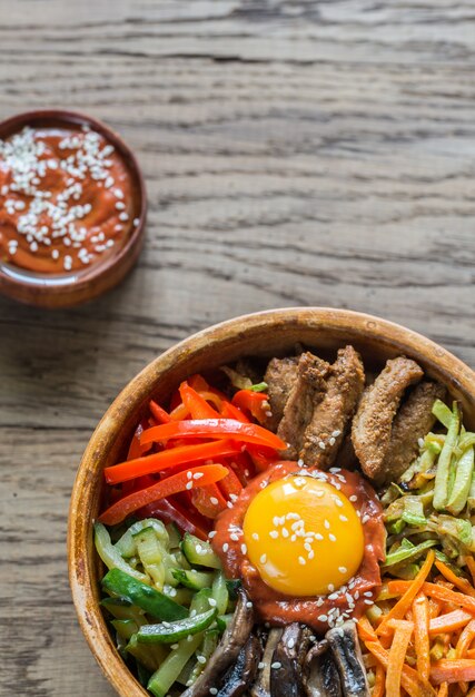 Kom Bibimbap op houten lijst