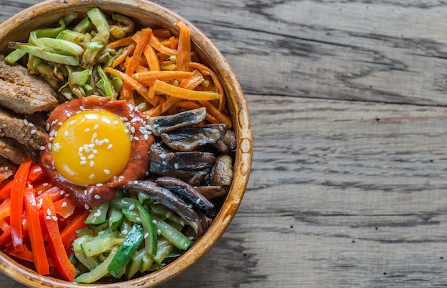 Kom Bibimbap op houten lijst