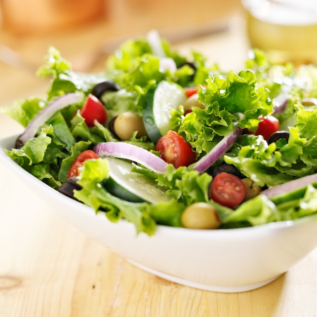 Kom bladgroene salade met olijven, tomaten en komkommer