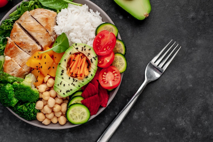 Foto kom boeddha. rijst, kipfilet, broccoli, pompoen, avocado, kikkererwten, wortelen, komkommer, bieten