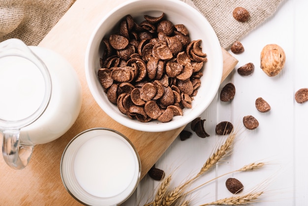 Kom chocoladevlokken met een glas melk op tafel