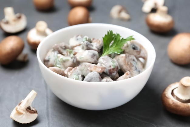 Kom gebakken champignons met saus op tafel close-up