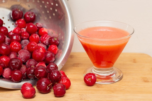 Kom gevuld met verse acerola's naast acerolasap