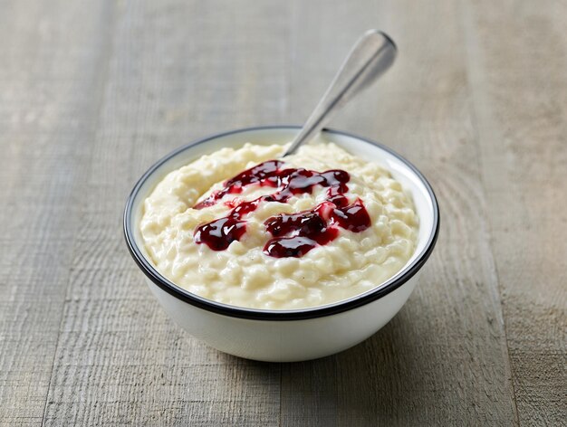 kom glutenvrije rijstmelkpudding met jam op houten keukentafel