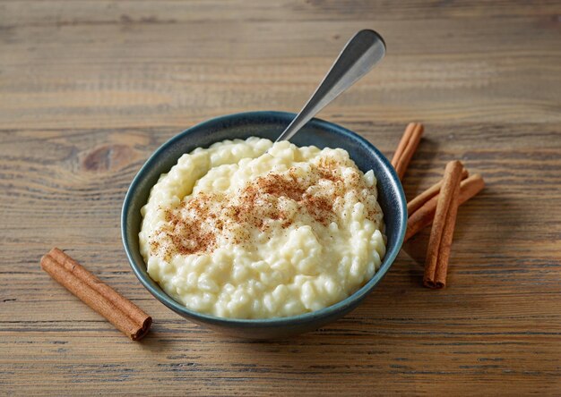 Kom glutenvrije rijstmelkpudding met kaneel op houten keukentafelbladweergave