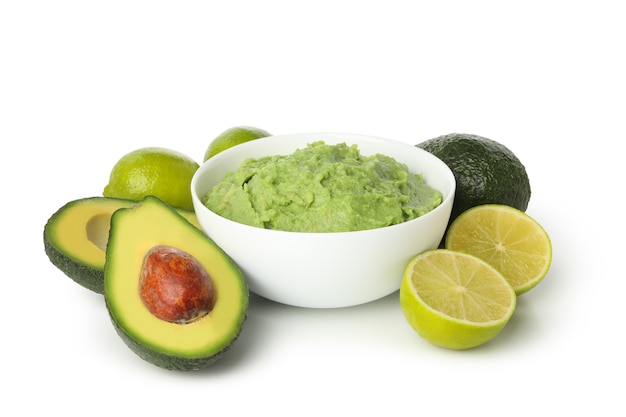 Kom guacamole, avocado en limoen geïsoleerd op een witte achtergrond