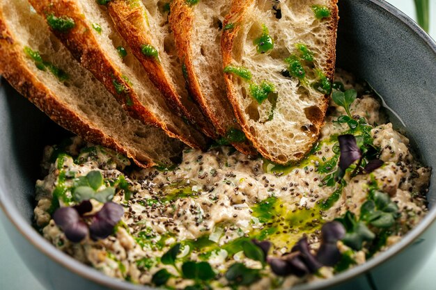 Kom hartige baba ghanoush met geroosterd brood op de blauwe achtergrond