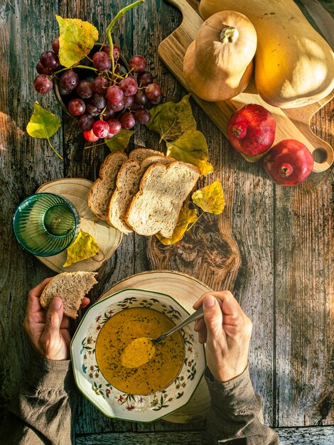 Kom hete pompoensoep in handen een kom veganistische pompoensoep vasthouden comfort food selectieve focus