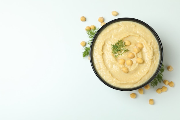 Kom hummus en dille op witte geweven muur