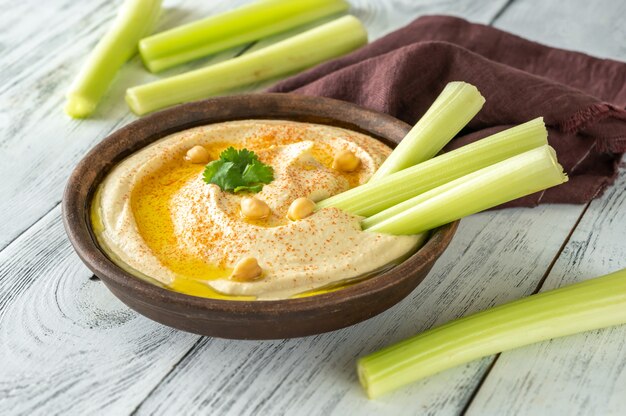 Kom hummus gegarneerd met olijfolie en paprika