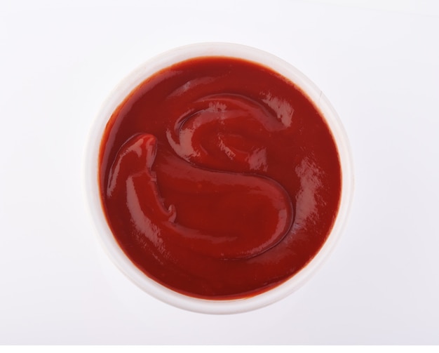 Kom ketchup of tomatensaus geïsoleerd op een witte achtergrond, bovenaanzicht