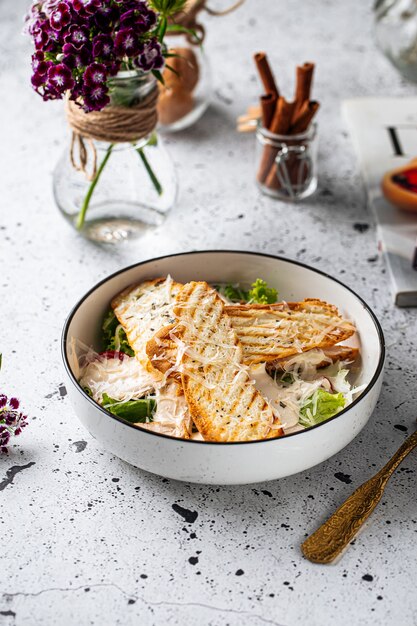 Kom kip Caesar salade op lichte achtergrond