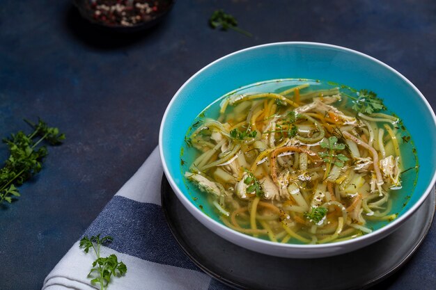 Kom kippensoep met vermicelli, kruiden en groenten