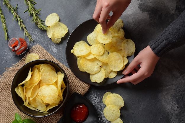 Kom knapperige zelfgemaakte chips geserveerd met ketchup, rozemarijn, kruiden en specerijen