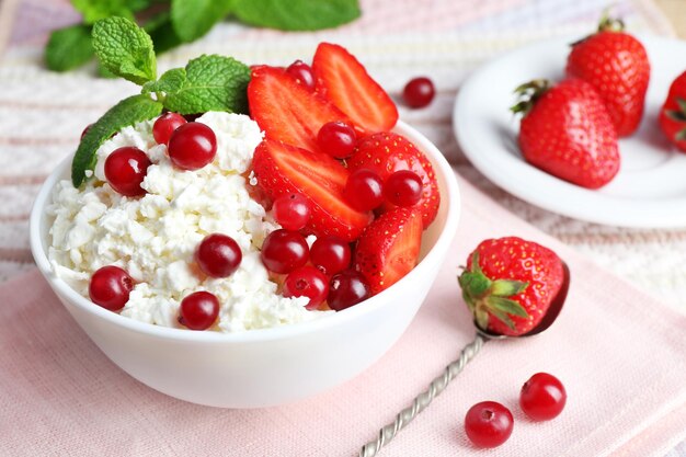 Kom kwark met aardbei en cranberry op tafel close-up